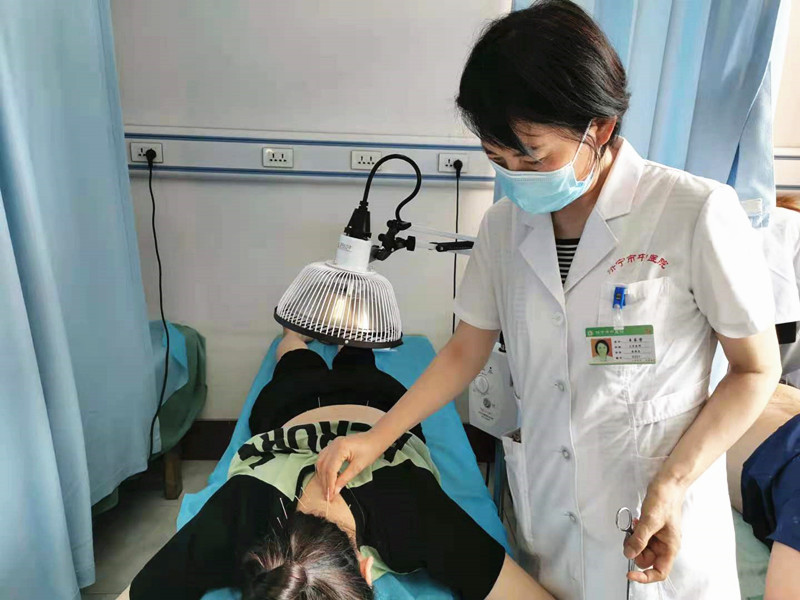 1622853619115987.jpg 4王乐荣为患者针灸治疗.jpg